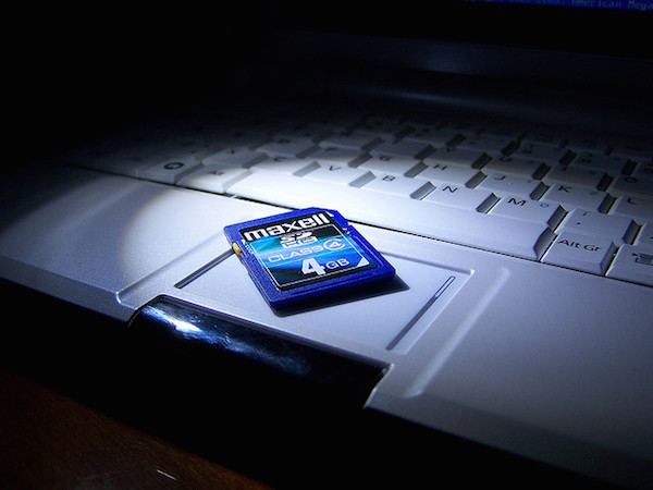 Foto di una scheda SDHC poggiata su un computer portatile