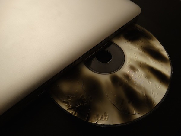 Foto che mostra un CD danneggiato inserito in un laptop